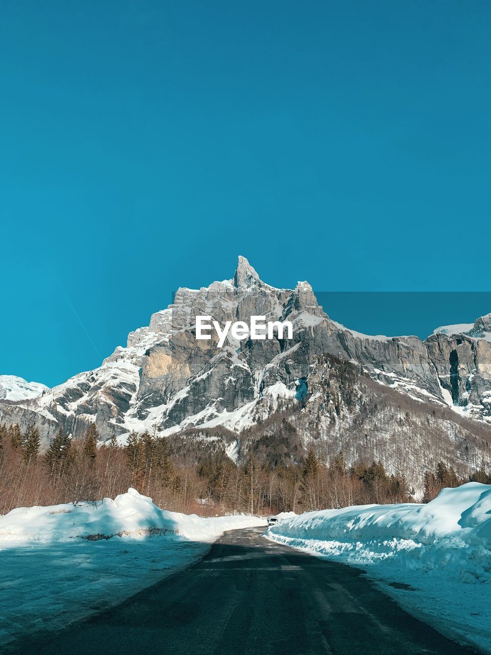 Scenic view of snowcapped mountains against clear blue sky