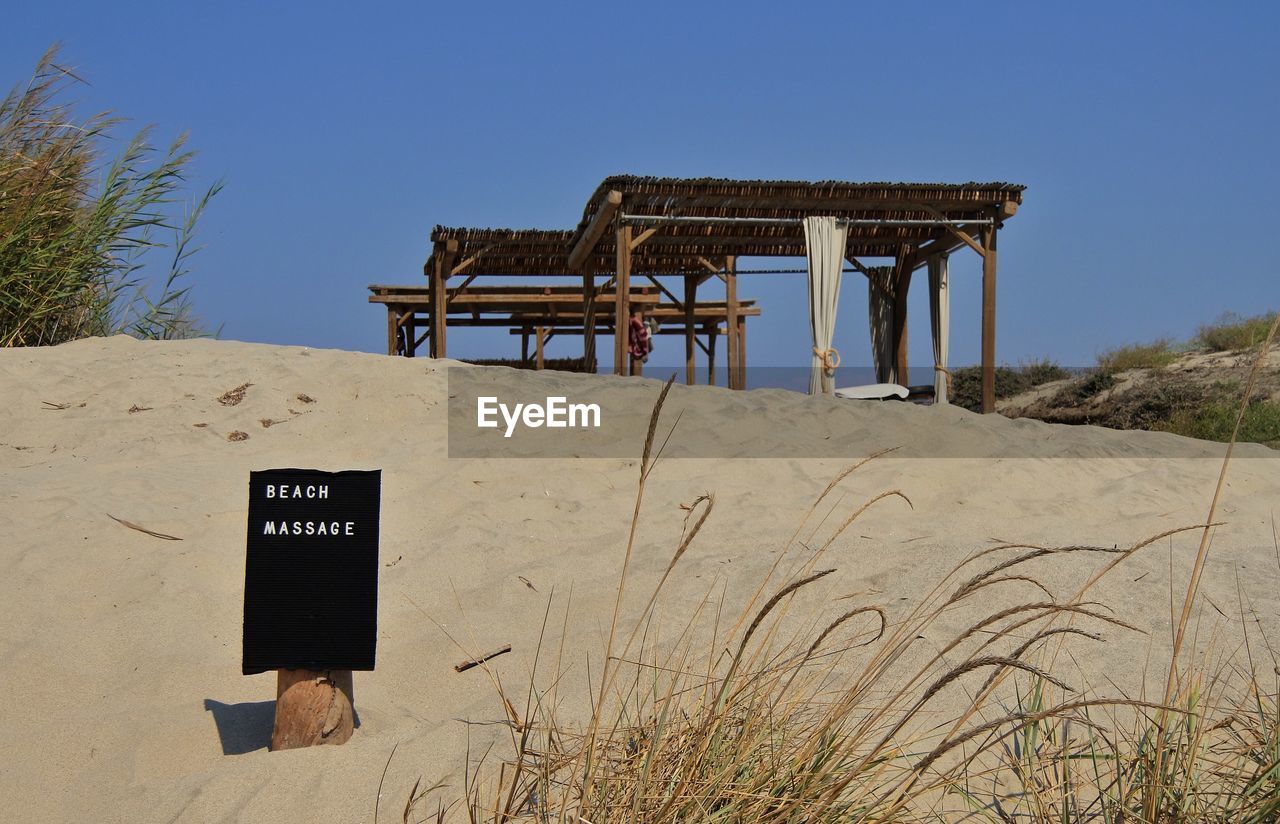 LIFEGUARD HUT ON BEACH AGAINST CLEAR SKY