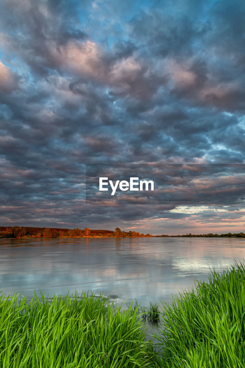 SCENIC VIEW OF LAKE AGAINST CLOUDY SKY