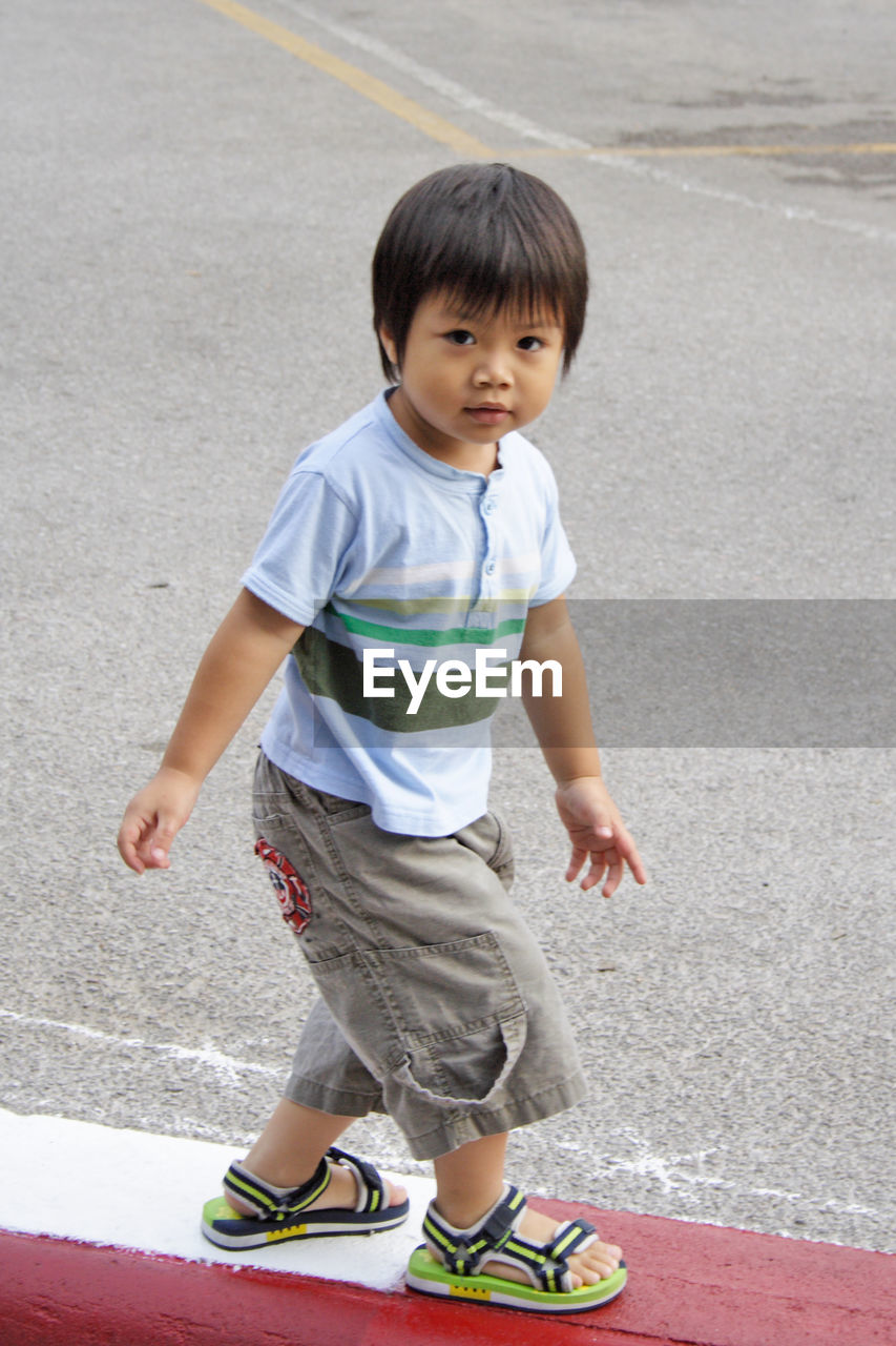 Portrait of cute boy walking on street