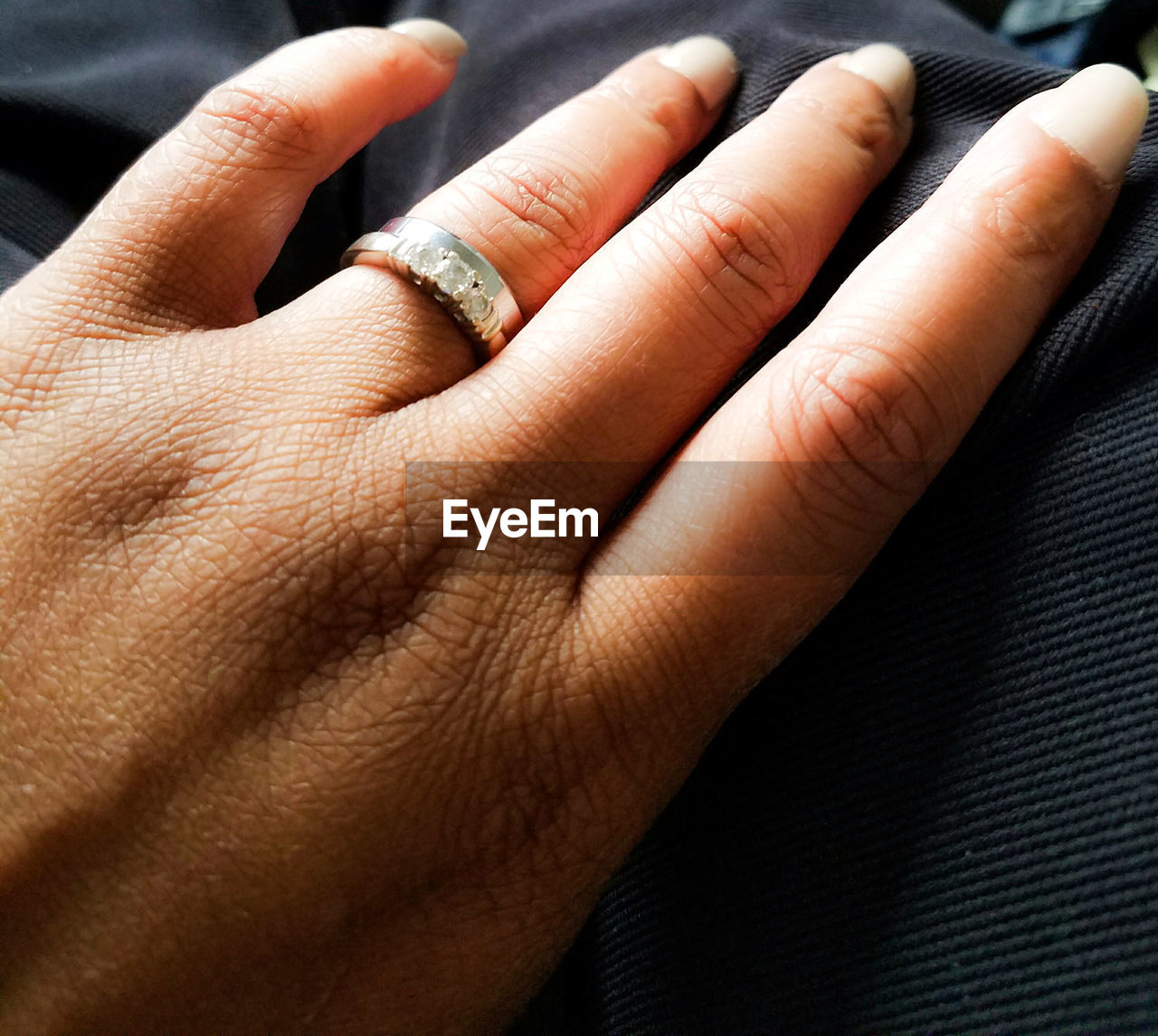 CLOSE-UP OF COUPLE HOLDING HANDS ON CARPET