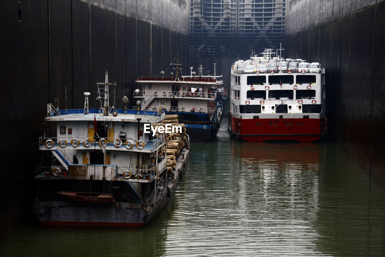 BOATS MOORED ON SEA BY BOAT AGAINST SKY