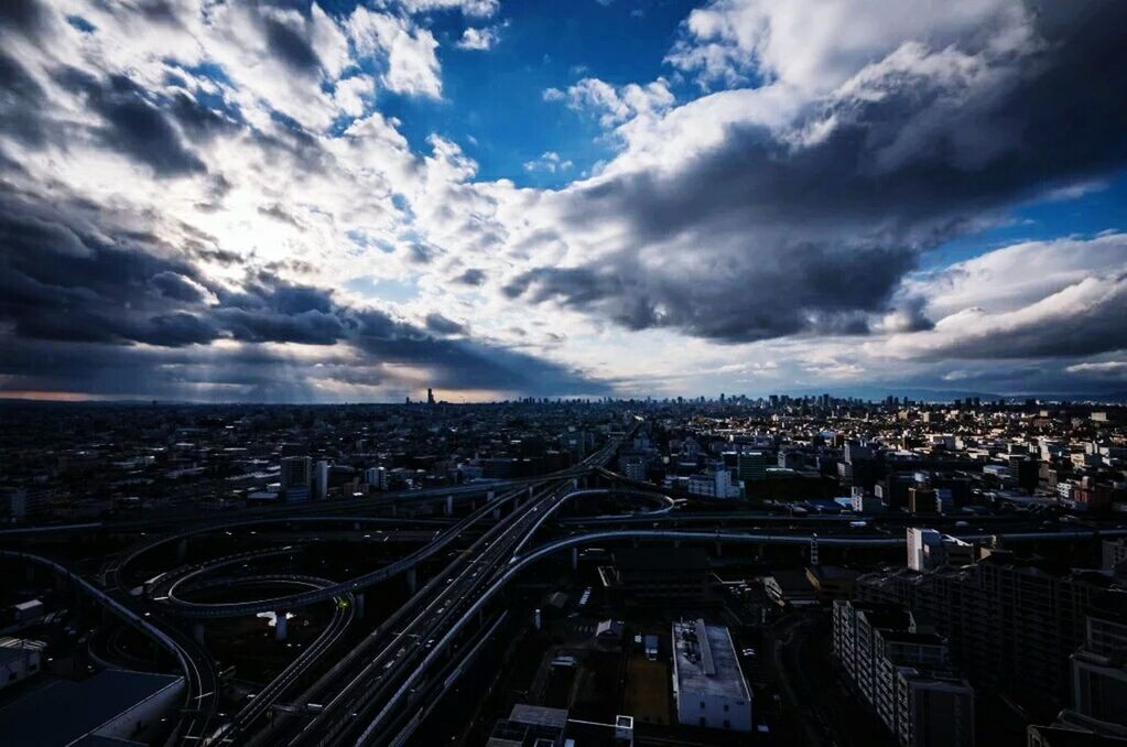 VIEW OF CITYSCAPE AGAINST CLOUDY SKY