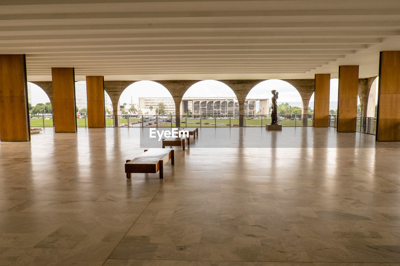 EMPTY CHAIRS AND TABLES ON TILED FLOOR