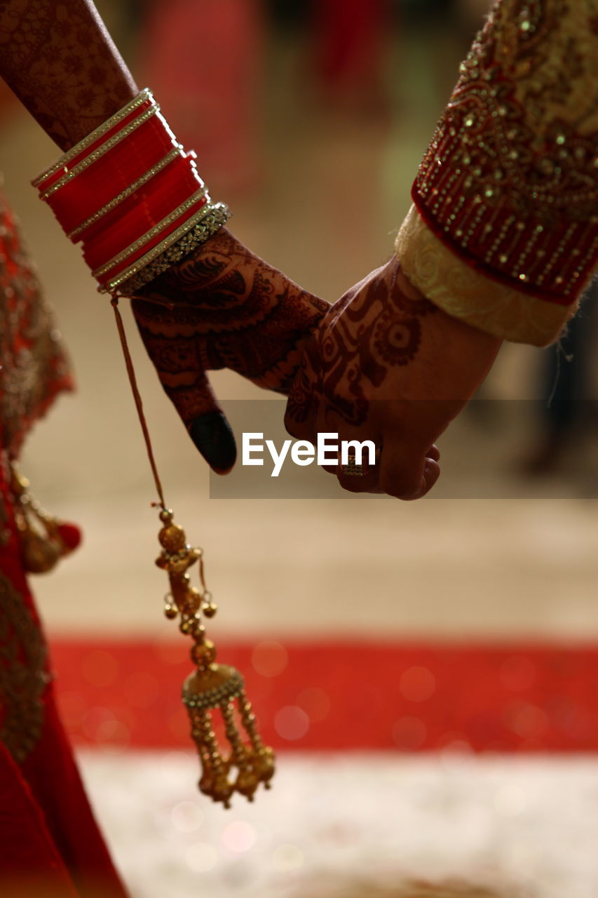 Cropped image if couple holding hands during wedding ceremony