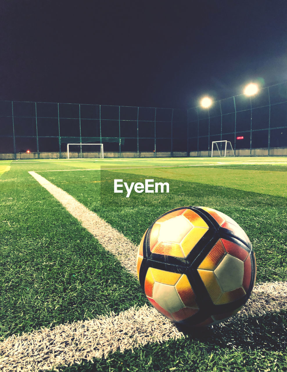 Close-up of soccer ball on field at night
