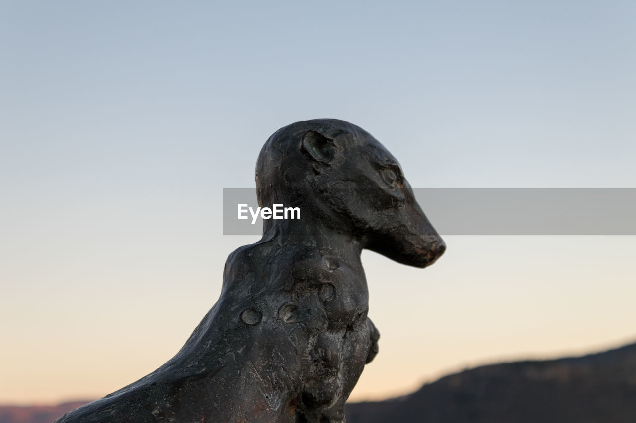 CLOSE-UP OF STATUE AGAINST SKY