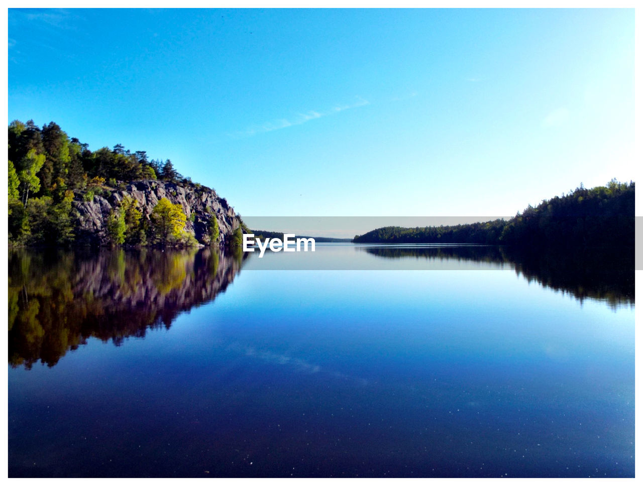 SCENIC VIEW OF CALM LAKE AGAINST SKY