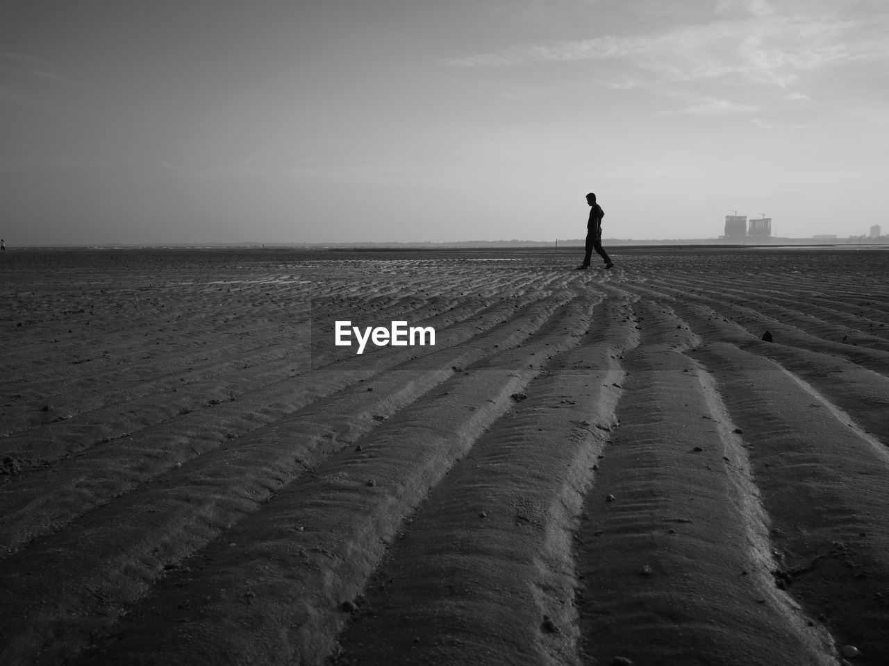 Silhouette man standing on beach against sky