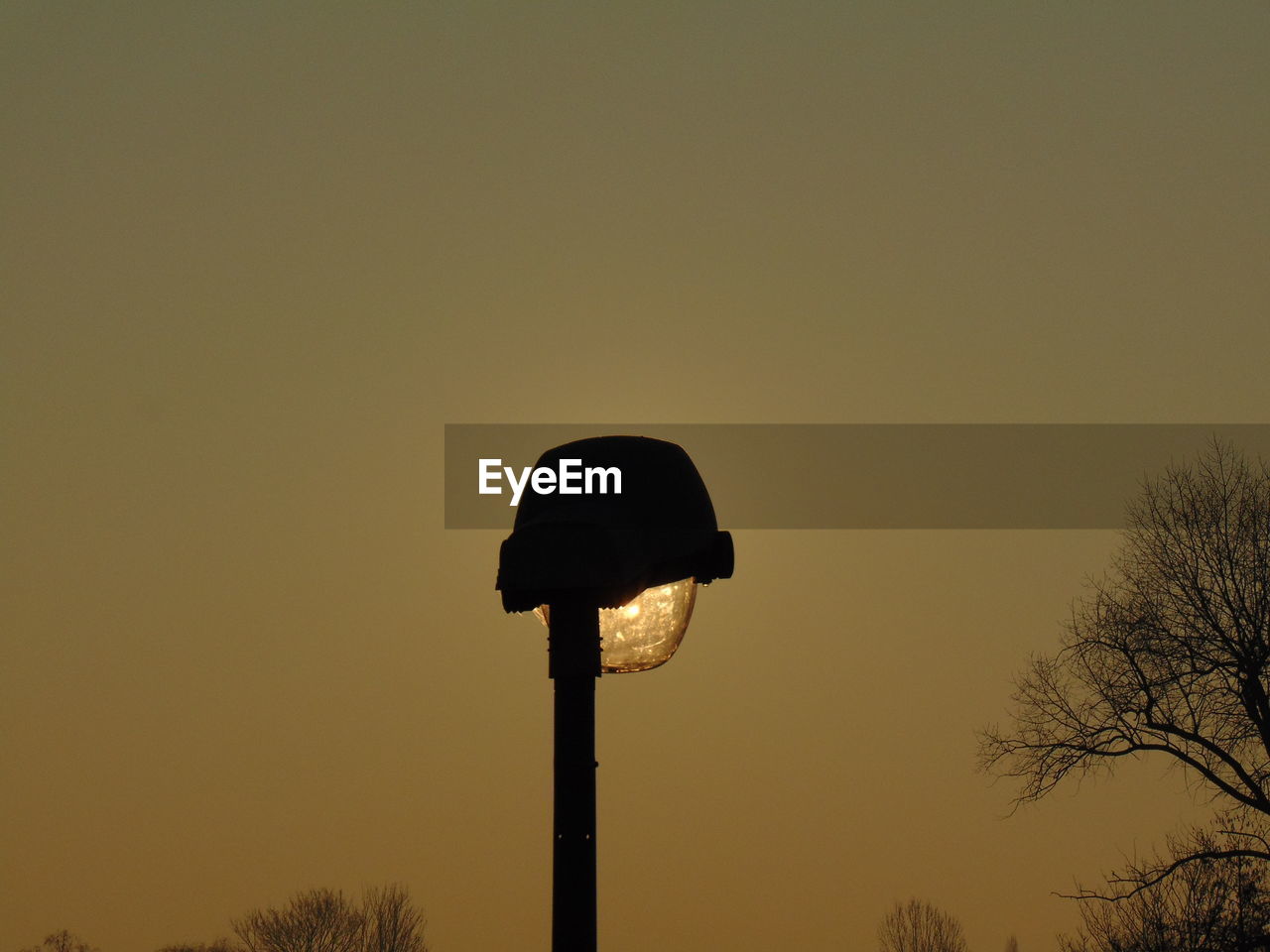 LOW ANGLE VIEW OF STREET LIGHT AGAINST CLEAR SKY DURING SUNSET