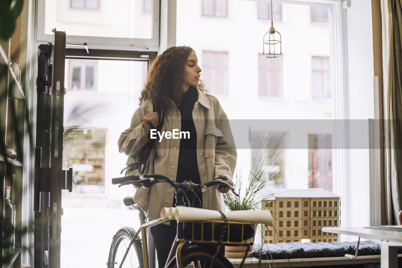 Female architect arriving at office with bicycle