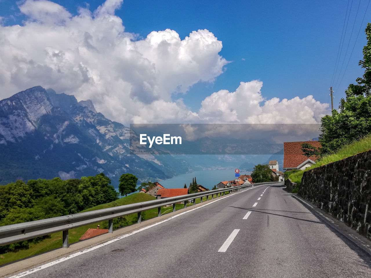 Road by mountains against sky