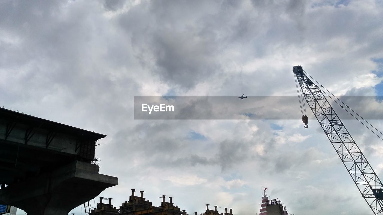 LOW ANGLE VIEW OF BUILDINGS IN CITY AGAINST CLOUDY SKY