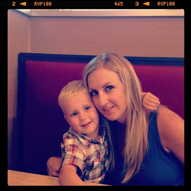 Portrait of happy woman with son sitting at restaurant