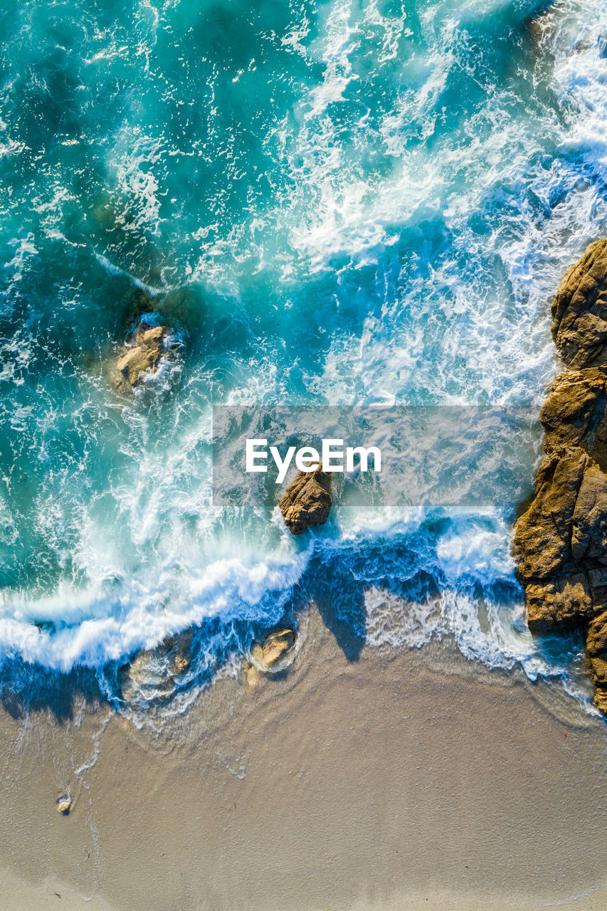 Aerial image of waves hitting the coastline of the french island corse near the village lumio.