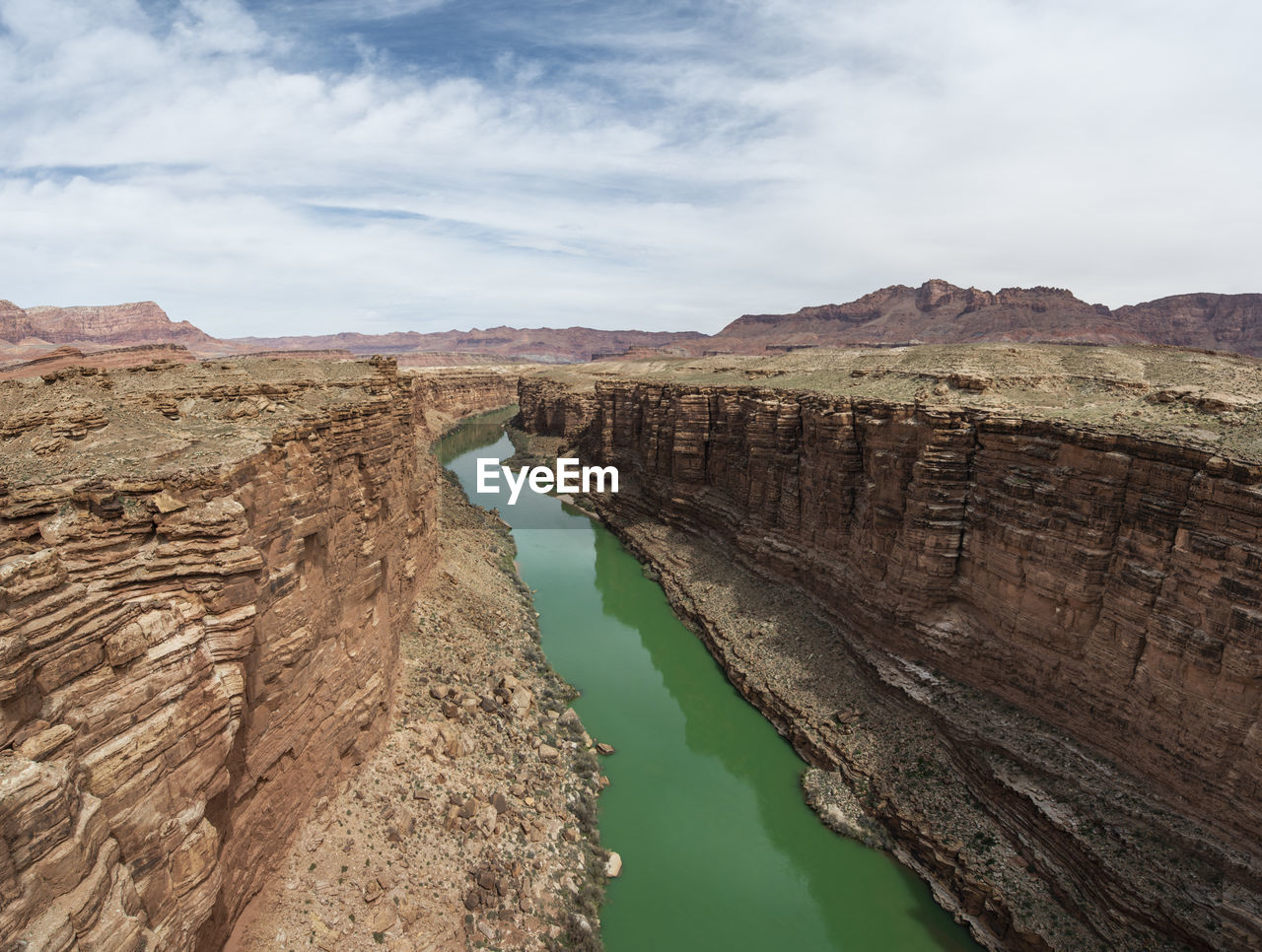 The colorado river cuts a green line through the desert in marbl