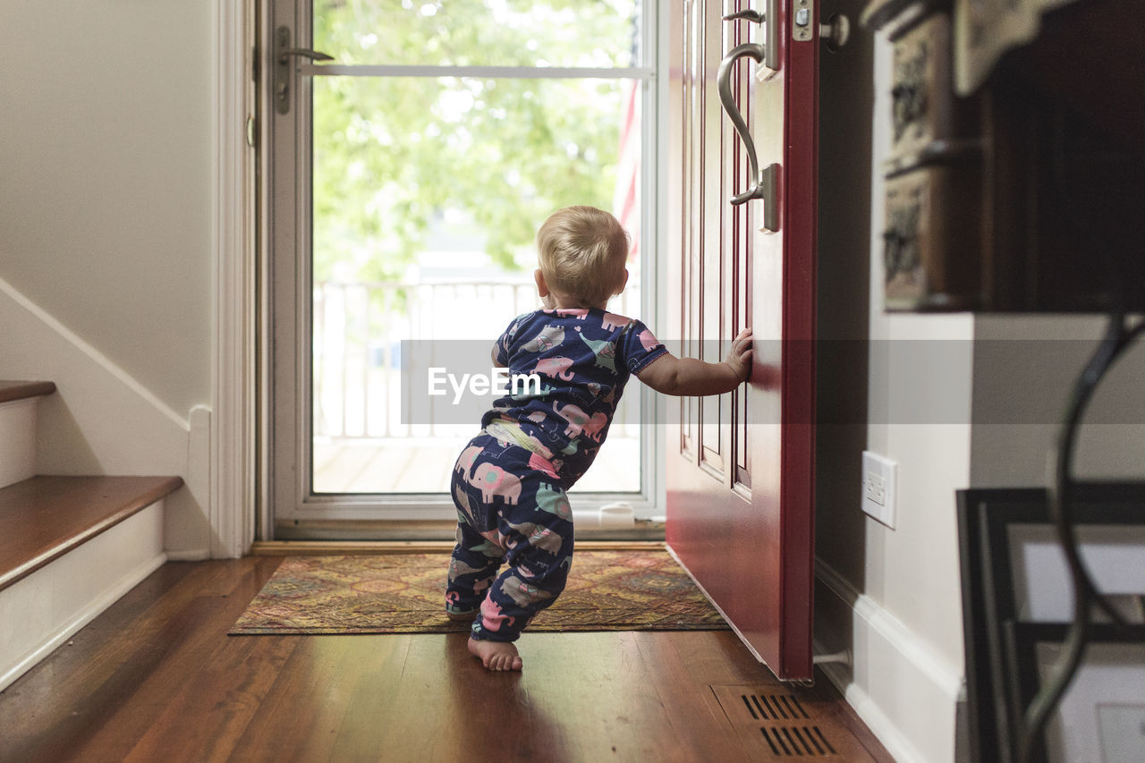 Baby girl standing at doorway