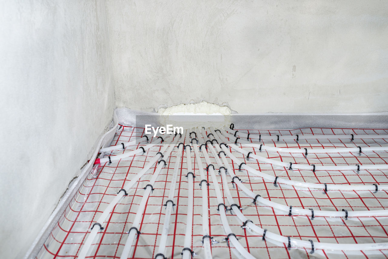 White pipes of underfloor heating systems, distributed in an individual family house on  foil.