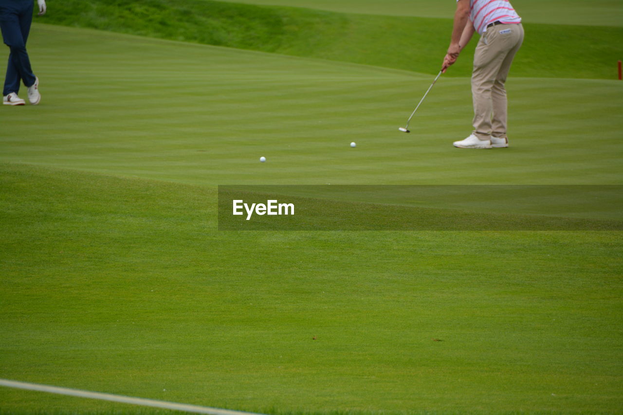 Low section of man playing on golf course