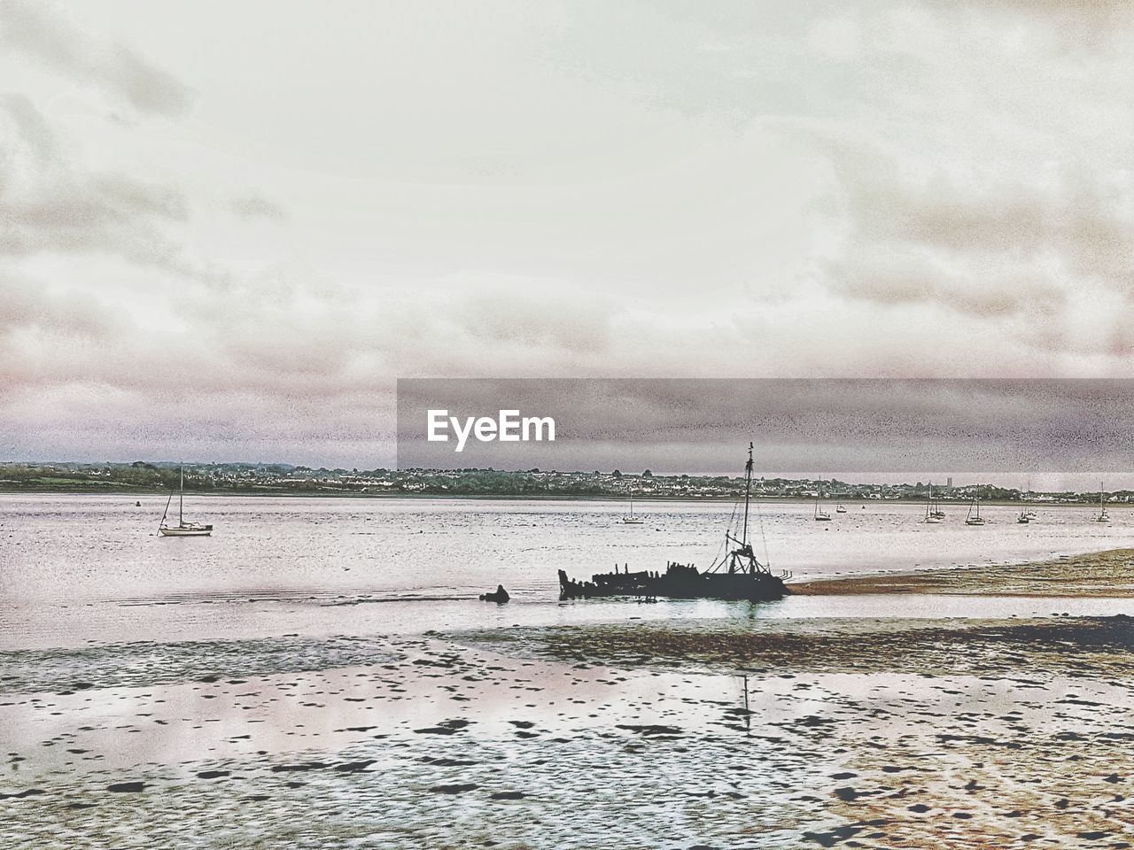 BOATS MOORED IN SEA AGAINST SKY