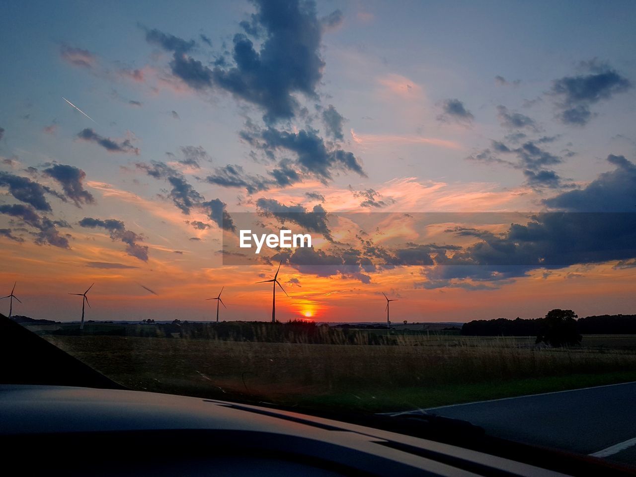 SCENIC VIEW OF SUNSET SEEN THROUGH CAR WINDSHIELD