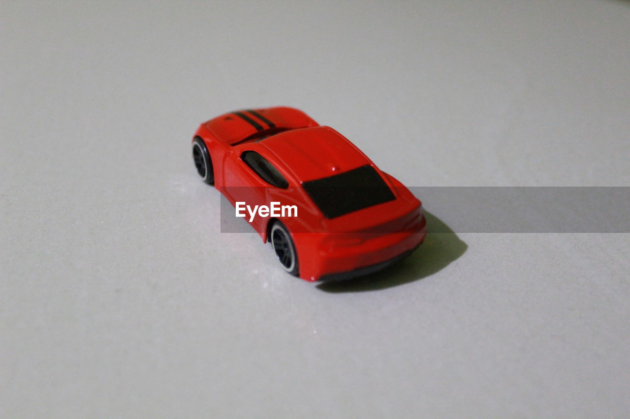 HIGH ANGLE VIEW OF TOY CAR ON WHITE BACKGROUND