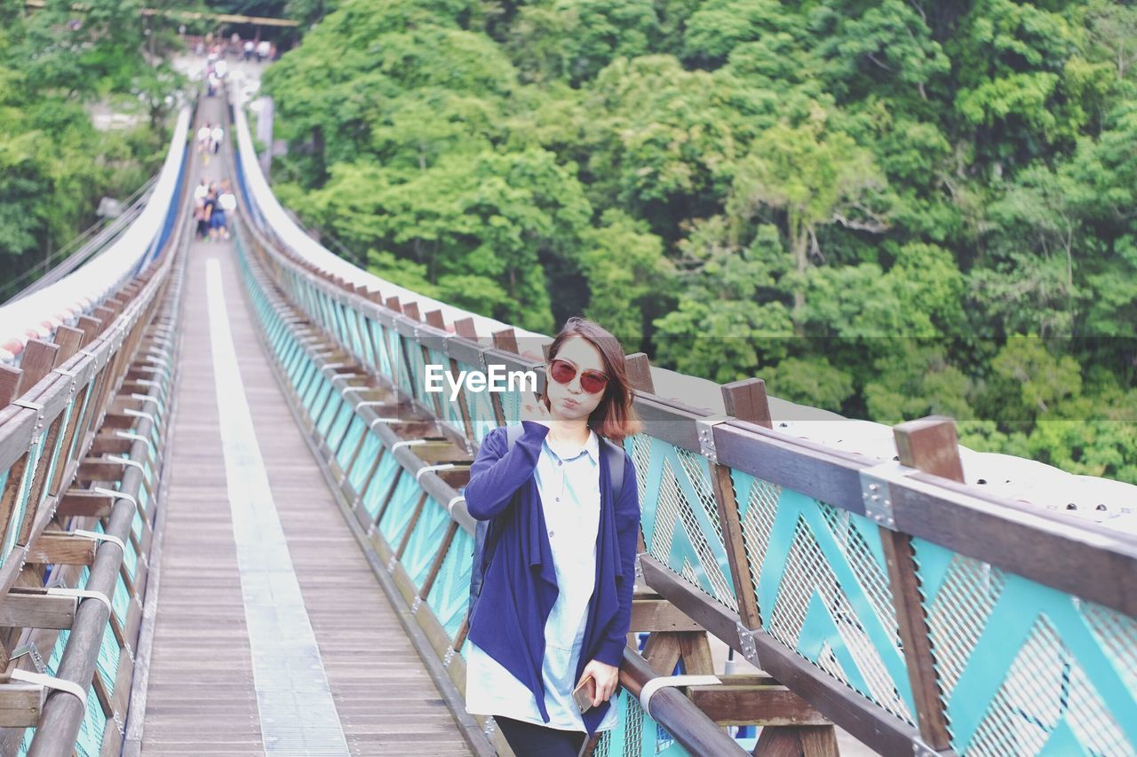 Woman standing on footbridge