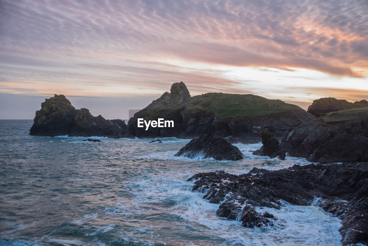 Scenic view of sea against sky during sunset at kynance cove