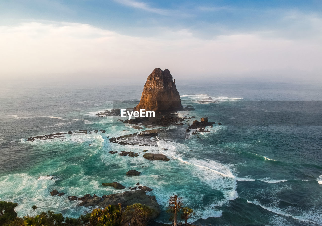 Scenic view of rocks in sea against sky