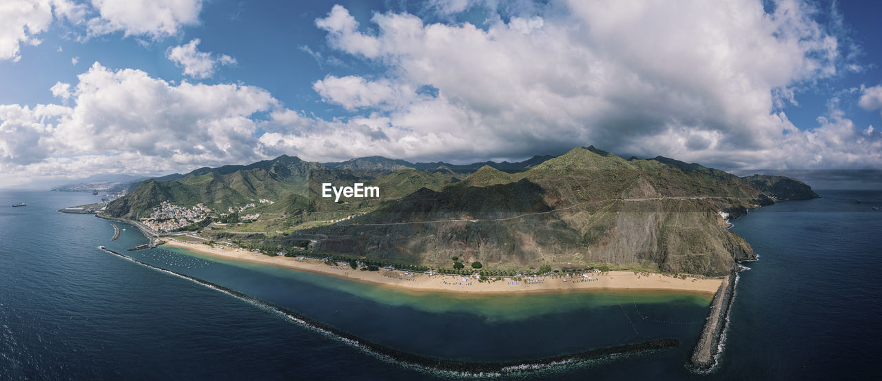 Panoramic view of sea and mountains against sky