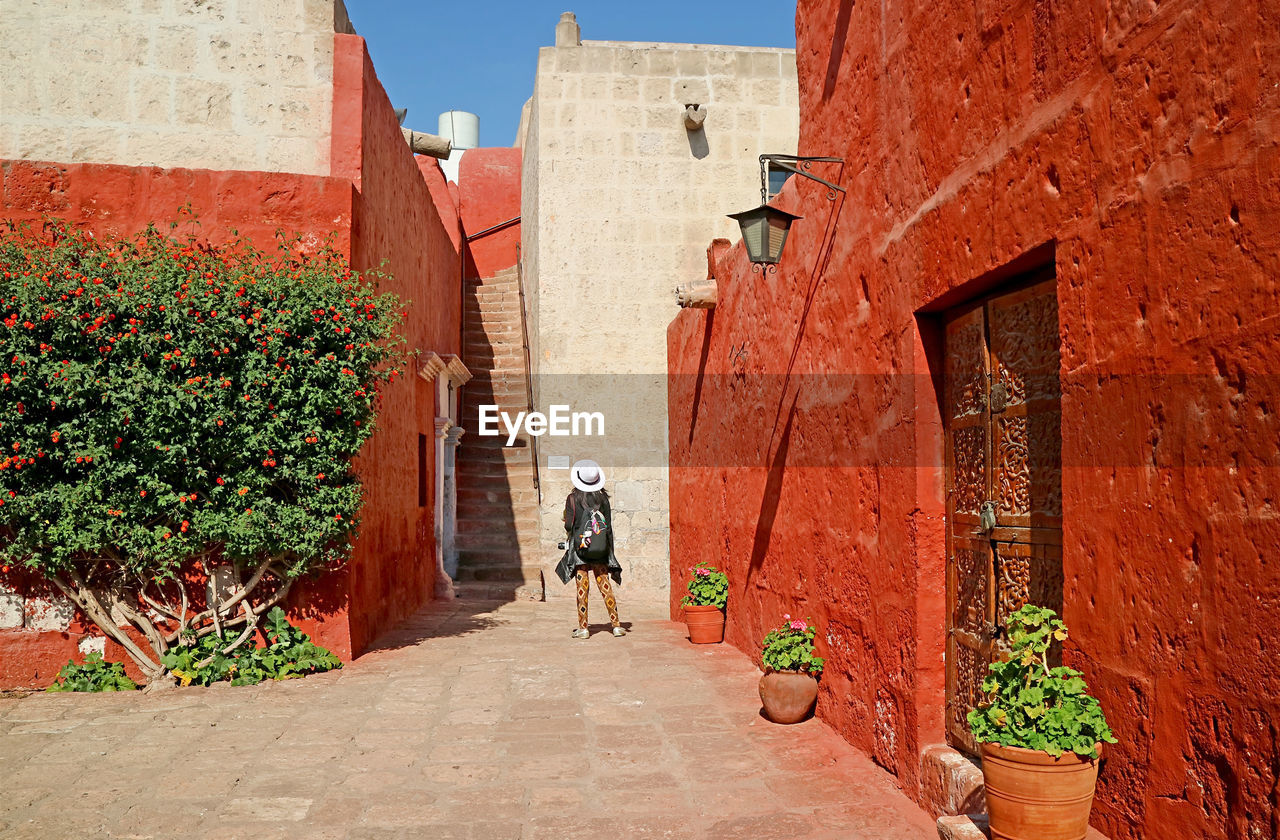Visitor being impressed by red and white buildings in convent of santa catalina, arequipa, peru