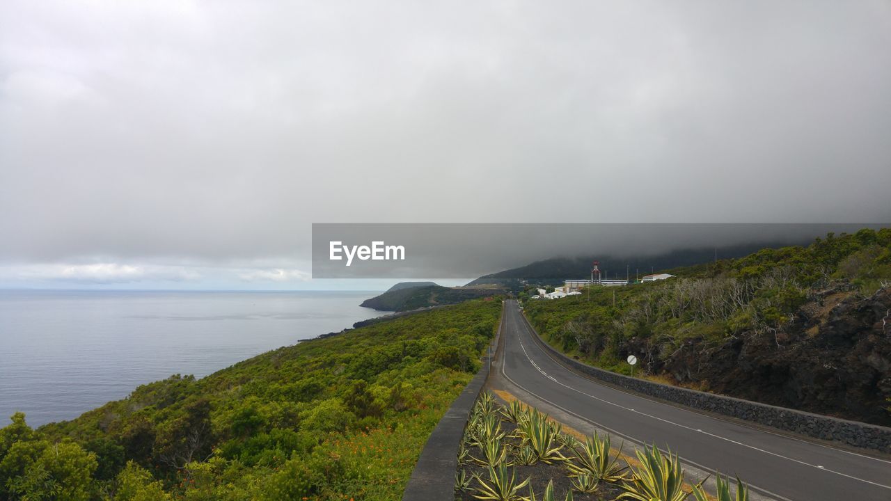 Empty road against cloudy sky