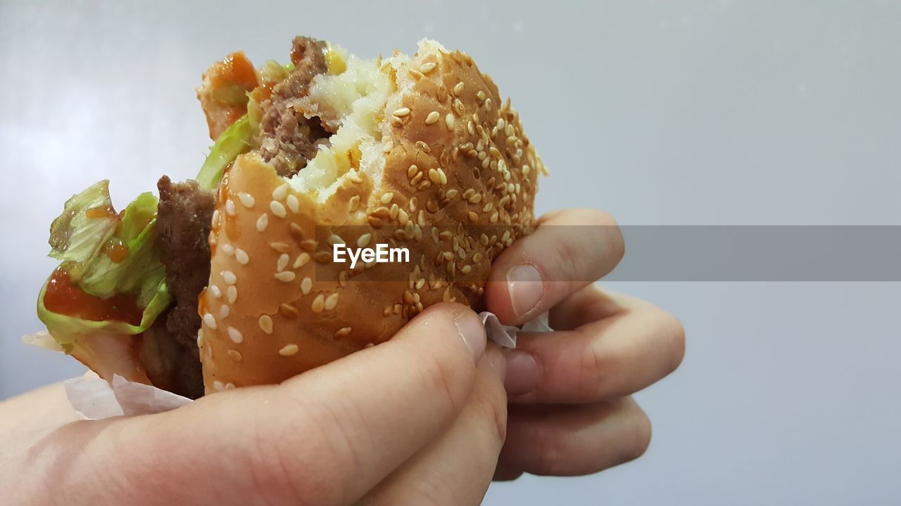 Close-up of hand holding hamburger