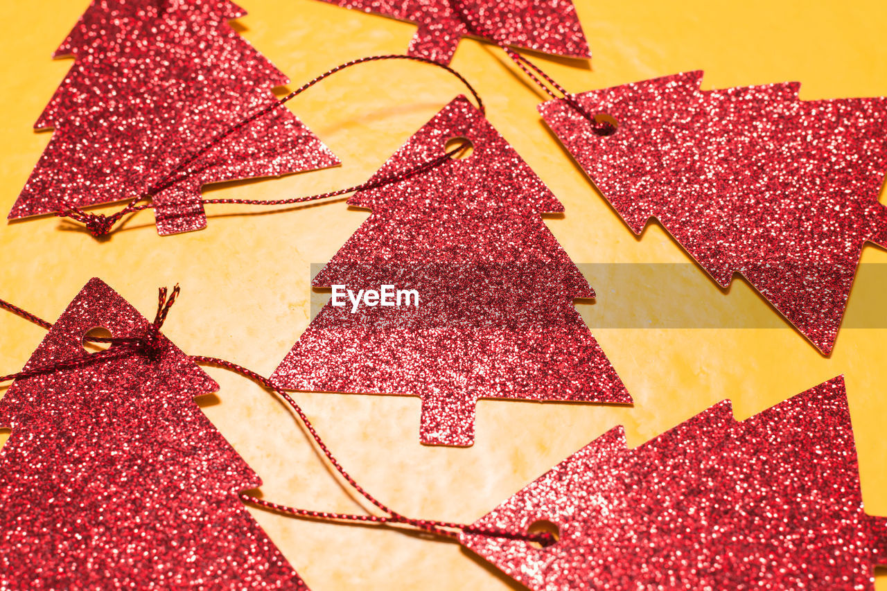 Red christmas tree ornaments arranged on yellow background