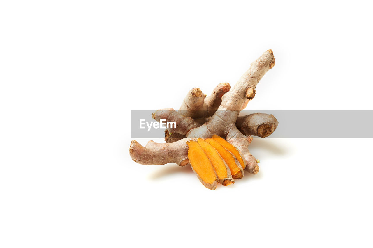 CLOSE-UP OF ORANGE MUSHROOM AGAINST WHITE BACKGROUND