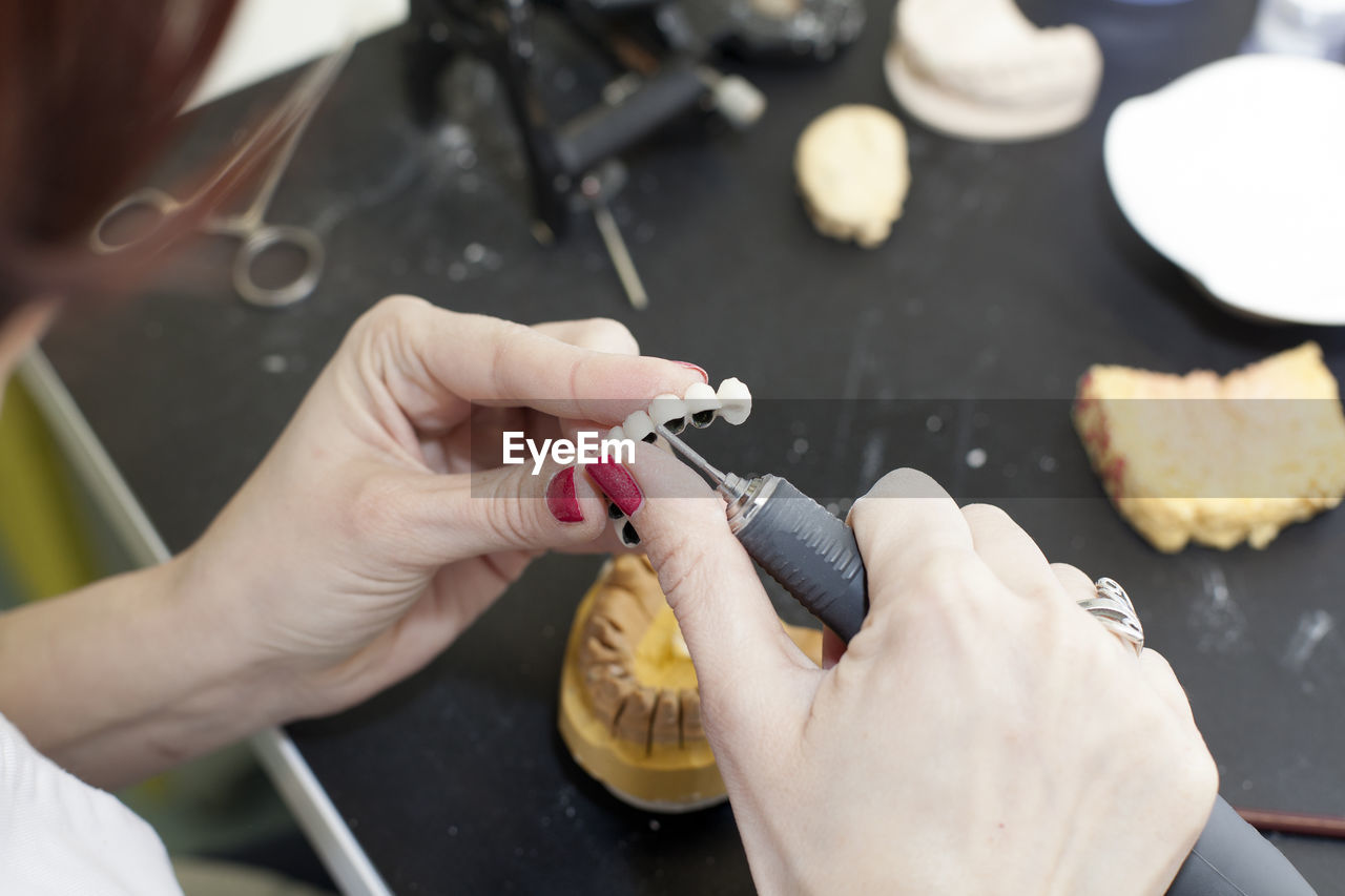 Cropped hands of woman carving small crown