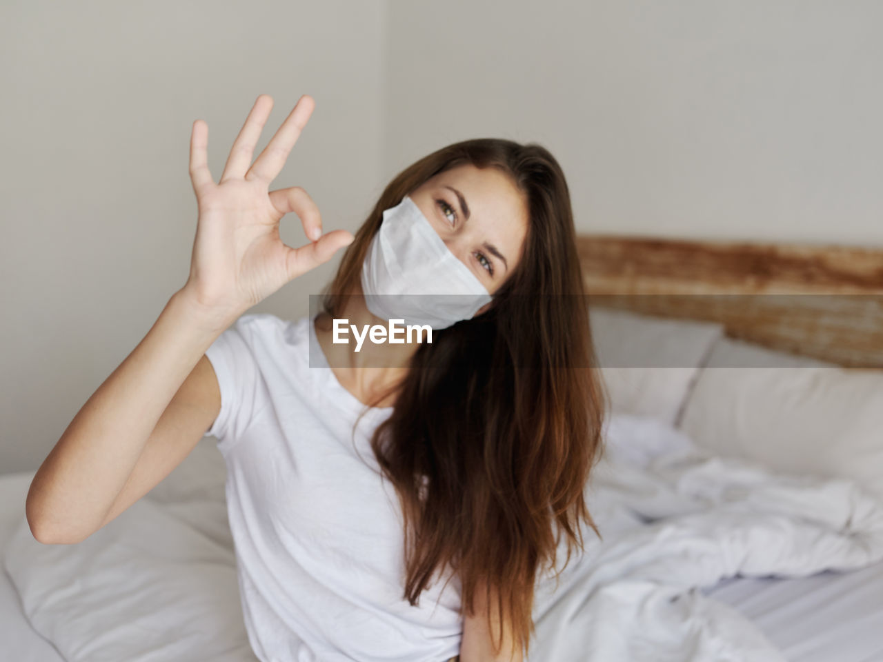 Portrait of young woman sitting on bed