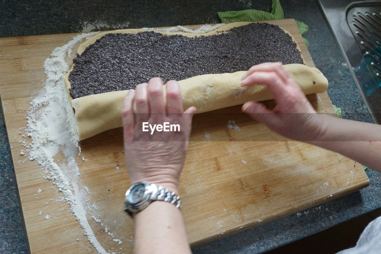 Cropped image of person preparing poppy seed cake in kitchen