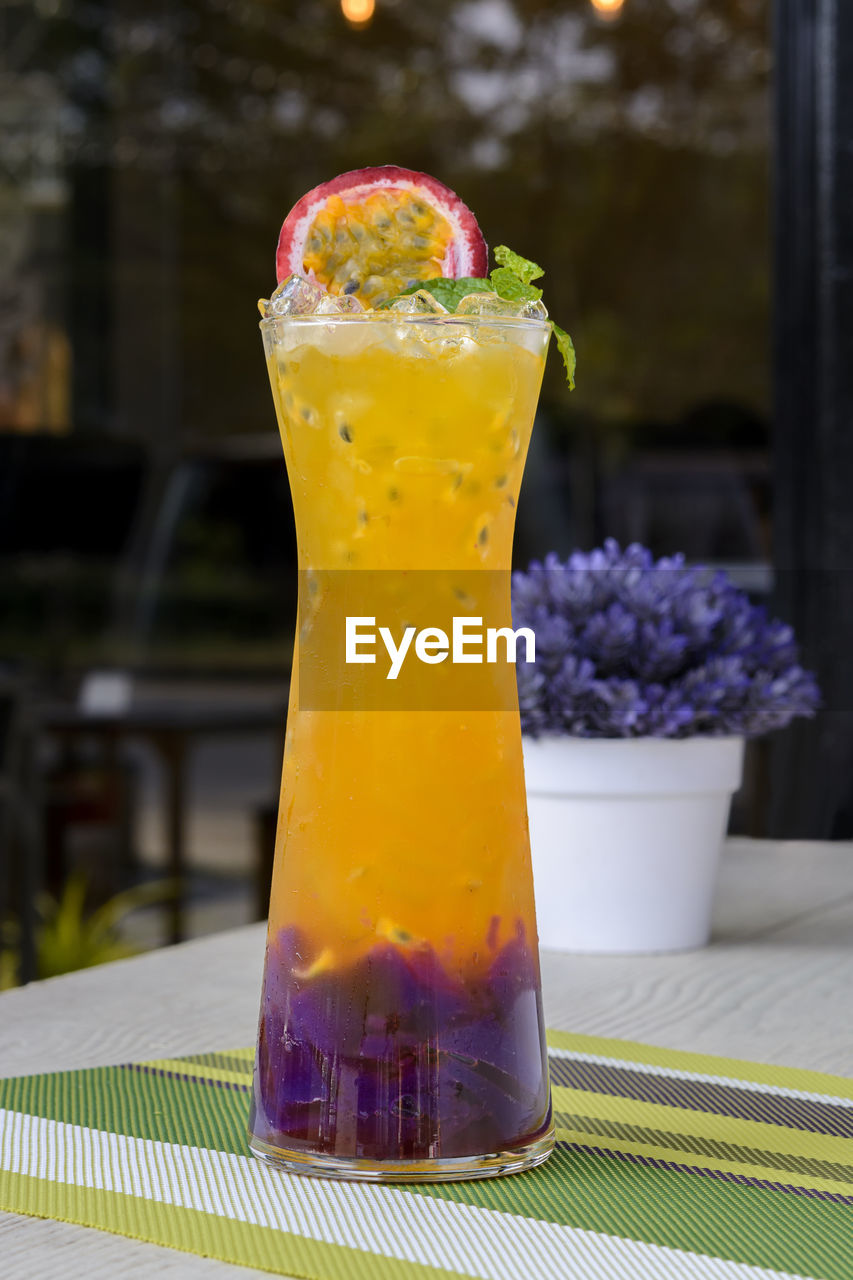 CLOSE-UP OF DRINK IN GLASS ON TABLE