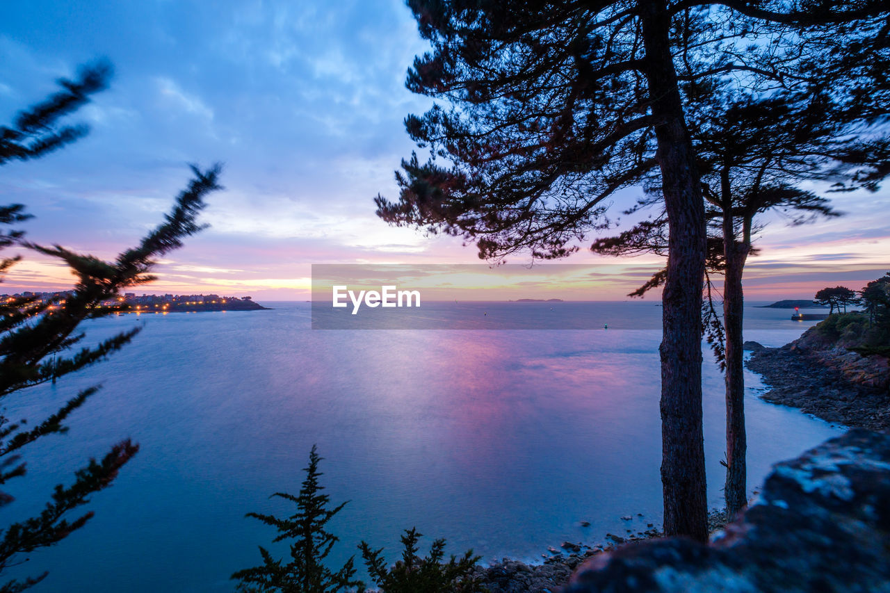 Scenic view of sea against cloudy sky at dusk