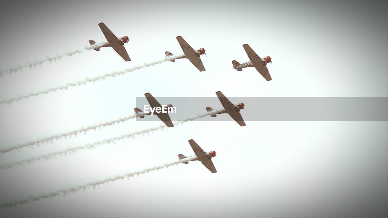 Low angle view of airshow in clear sky