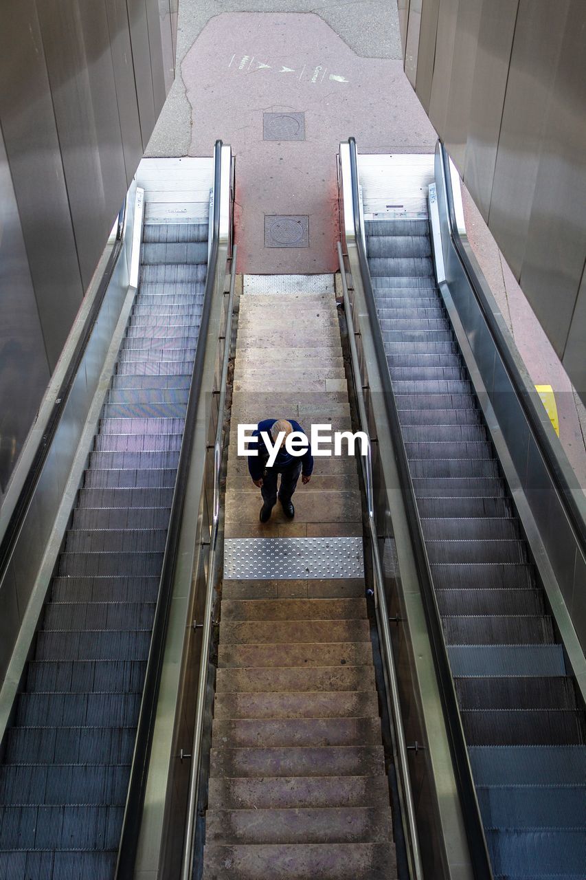 High angle view of man standing on escalator
