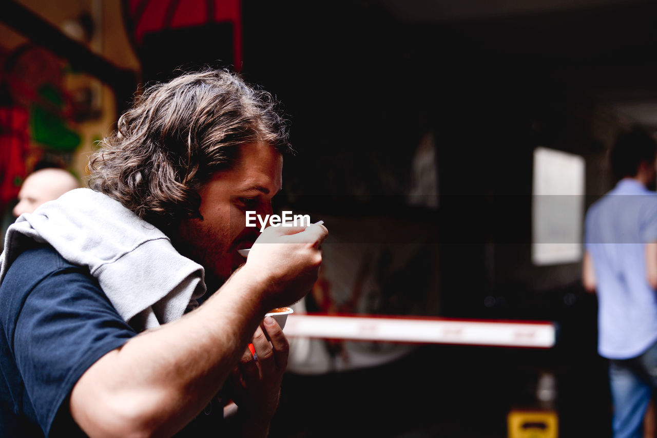 Man eating food while standing at market