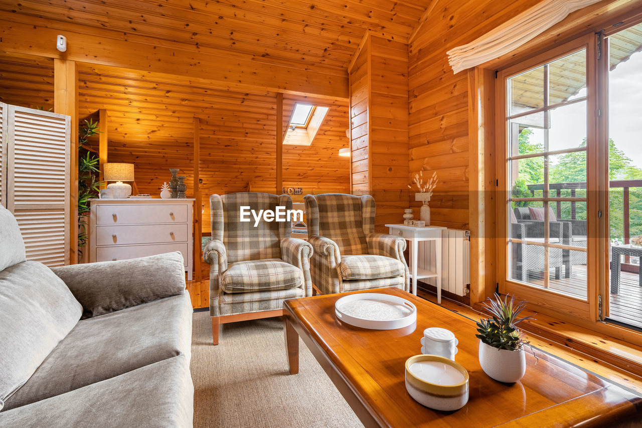 Cozy interior of a country house in a wooden design. living room with terrace and forest view