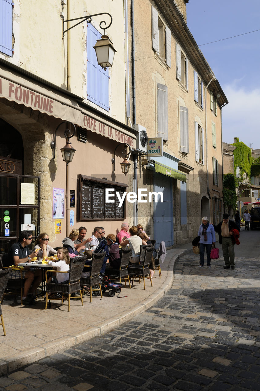 PEOPLE ON STREET BY BUILDING IN CITY