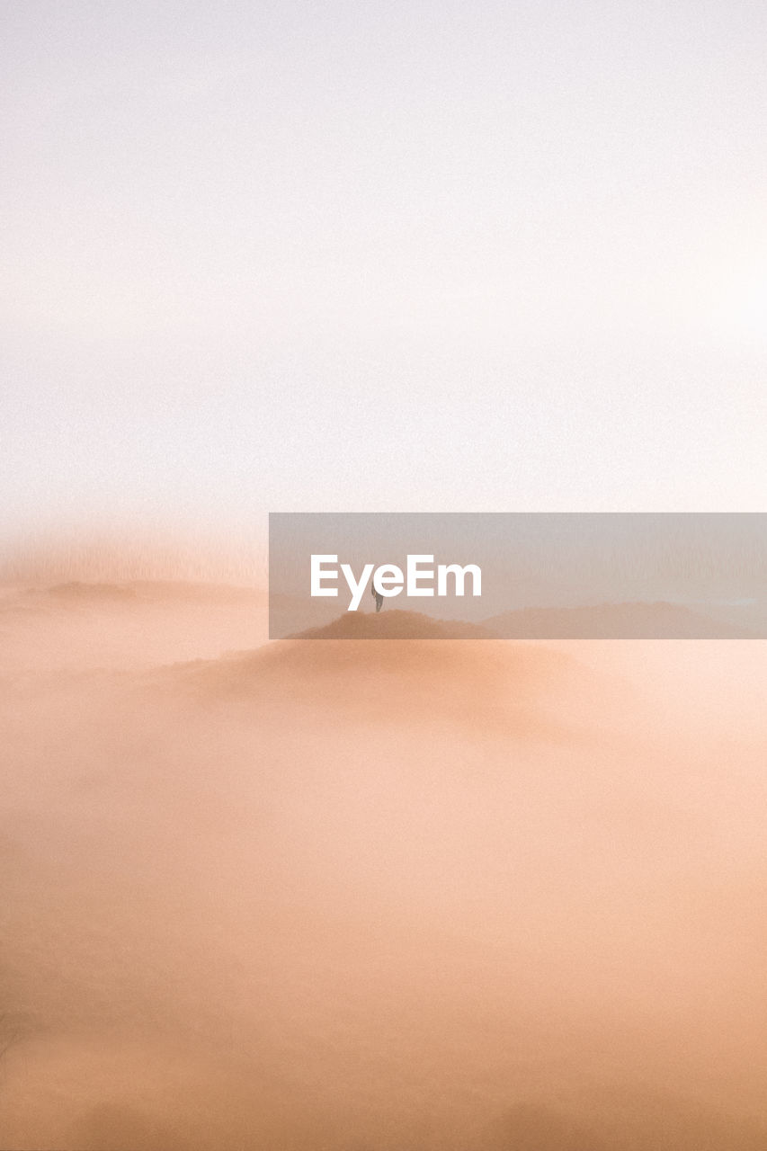 Man standing on desert against clear sky