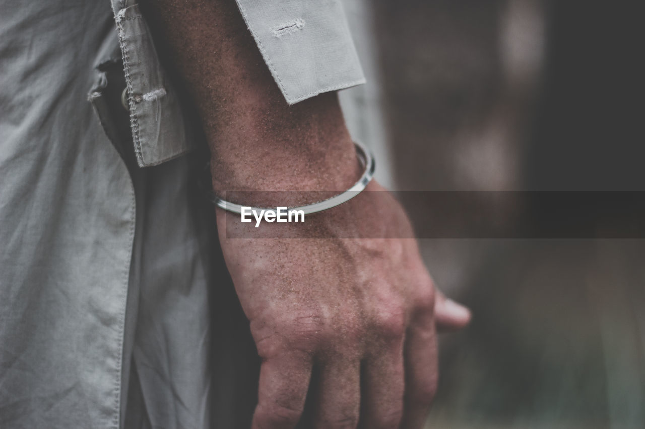 Midsection of man wearing bracelet