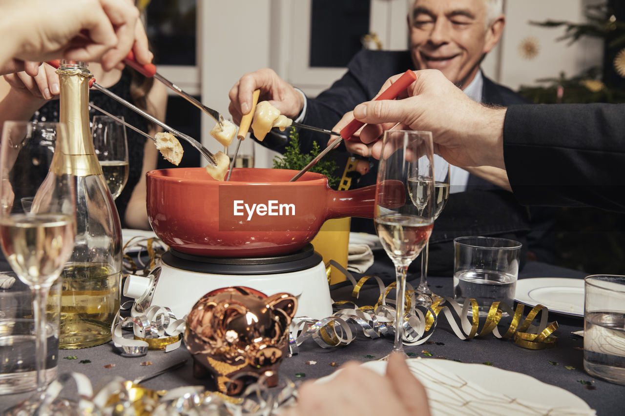 Friends eating cheese fondue on new year's eve