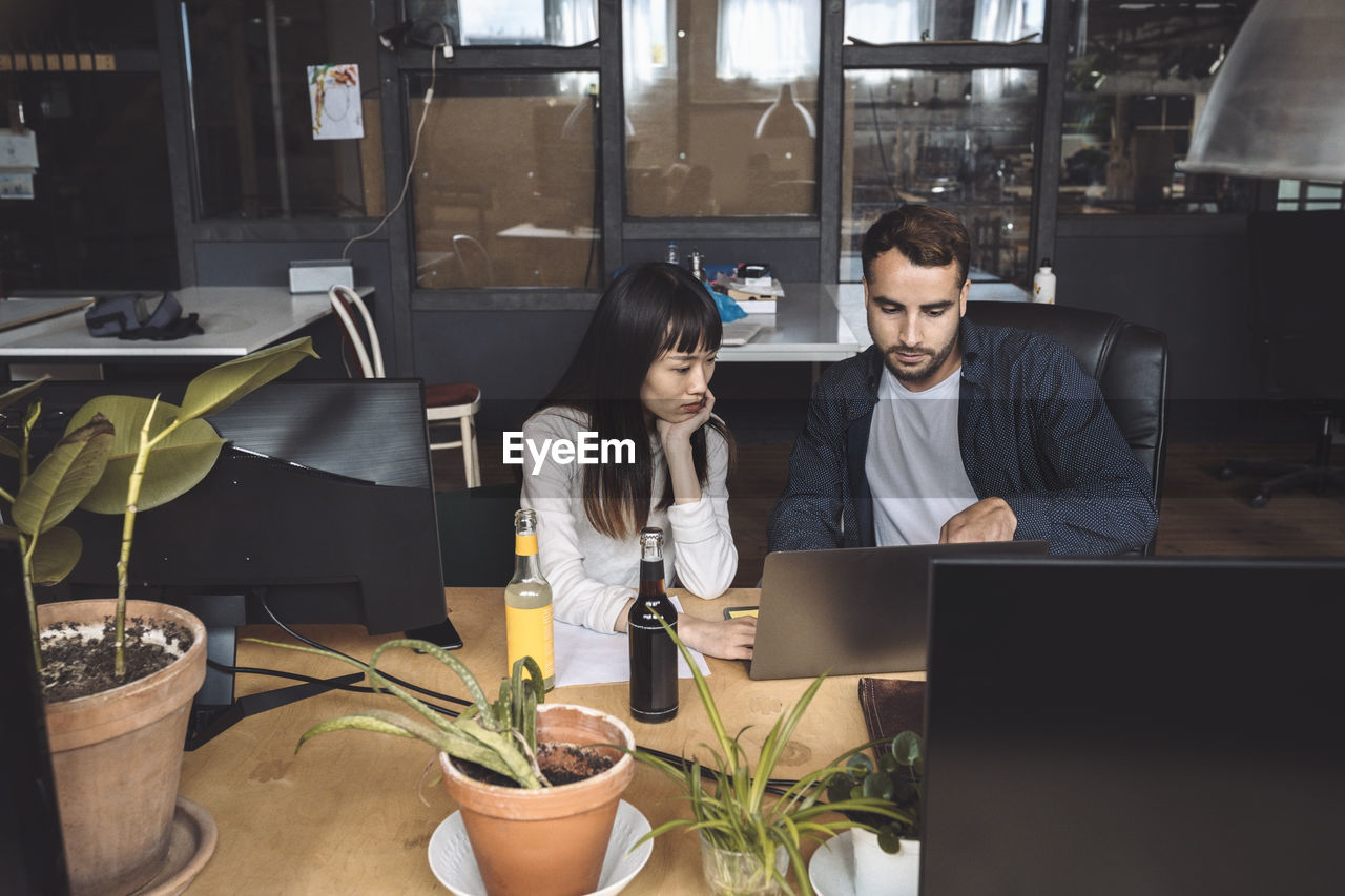 High angle view of colleagues discussing at workplace