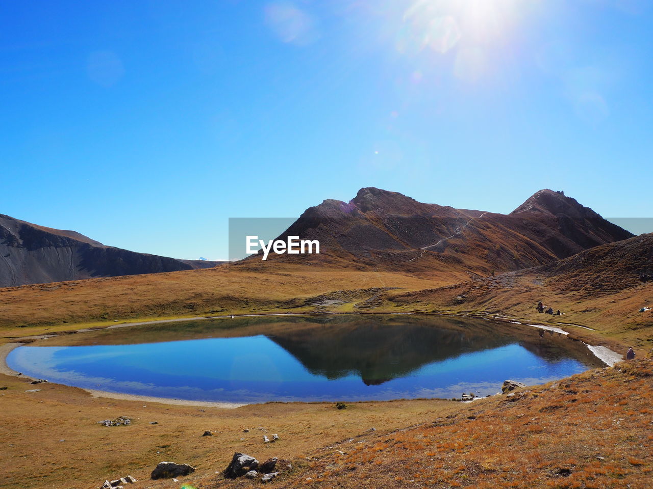 Scenic view of lake and mountains against blue sky